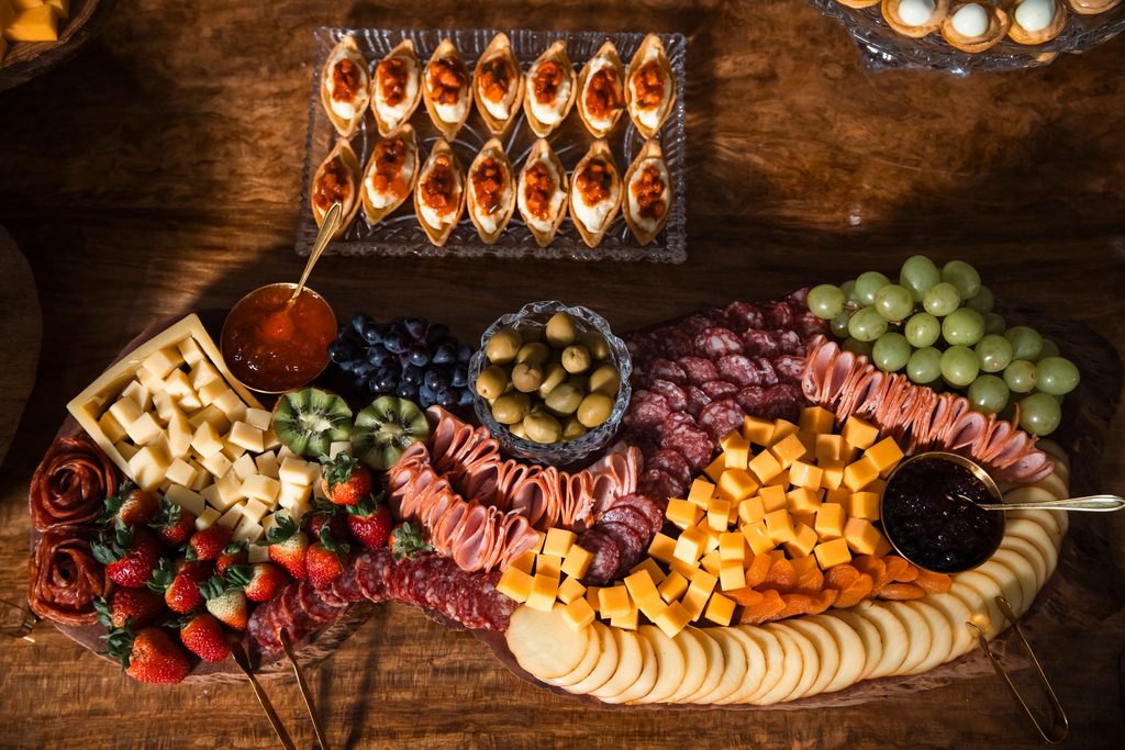 A lush charcuterie board with cheeses, fruits, meats, and olives. Perfect for parties or gourmet gatherings.